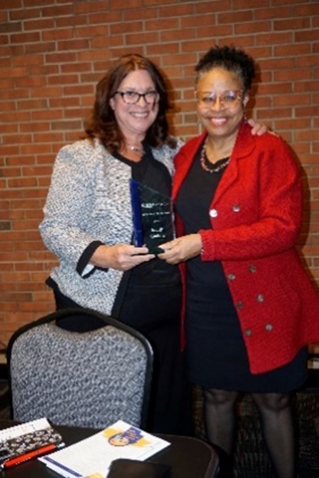 Judith Gaddie being given an award by another woman.