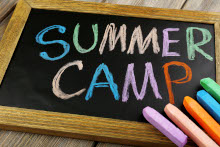 Chalk writing on a chalk board which reads, 'Summer Camp'