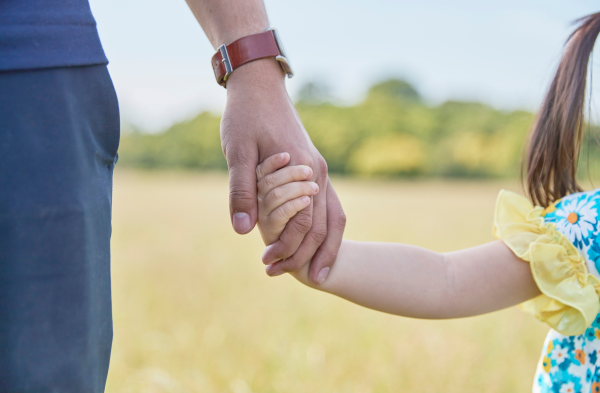 Parent holding a child's hand
