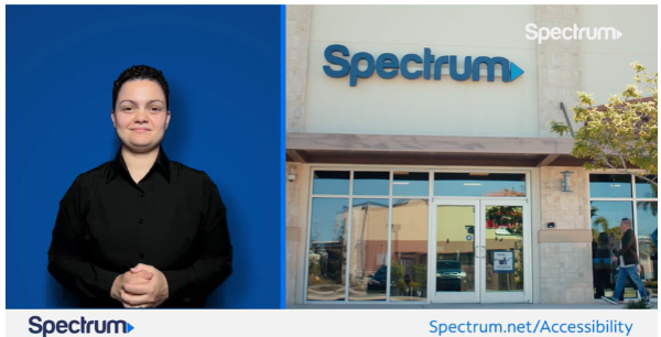 A smiling woman next to a Spectrum store.